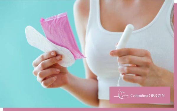 woman holding tampons and menstrual pad